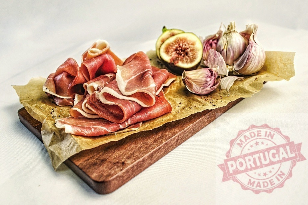 Prosciutto, figs, garlic arranged on wooden board | Sliced prosciutto ham with fresh figs and garlic on a wooden board - Realisiert mit Pictrs.com