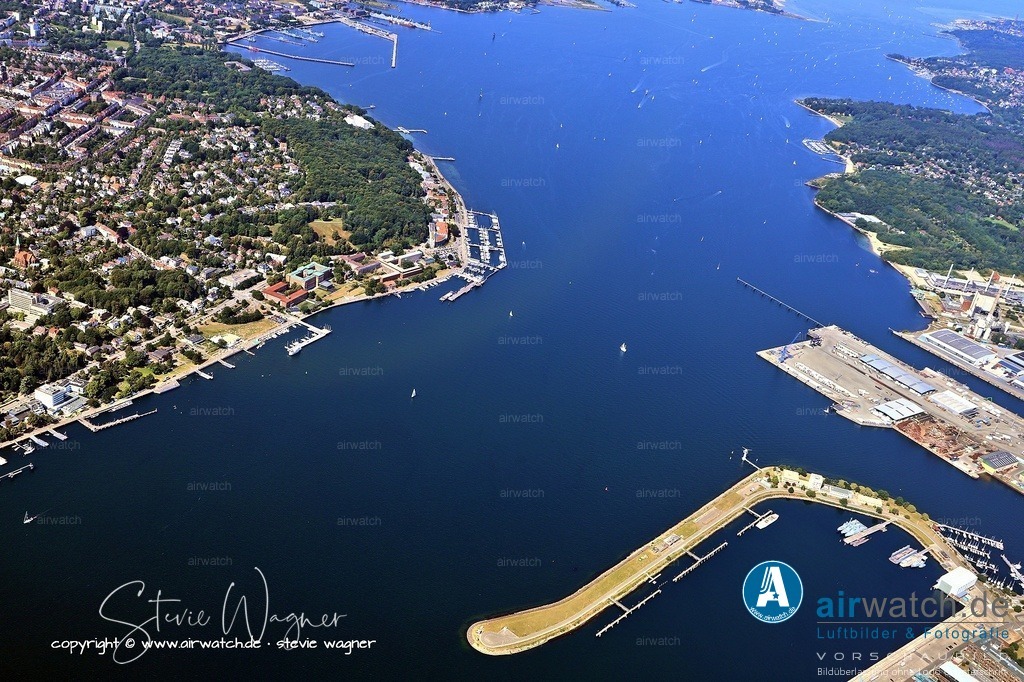 Luftbild Kiel Hafen - deutscher Marinehafen | Kiel wurde durch seine strategische Lage an der Förde zum bedeutendsten deutschen Marinehafen. Die Geschichte ist geprägt vom rasanten Aufstieg im Kaiserreich, revolutionären Umbrüchen und der heutigen Rolle als moderner Stützpunkt.