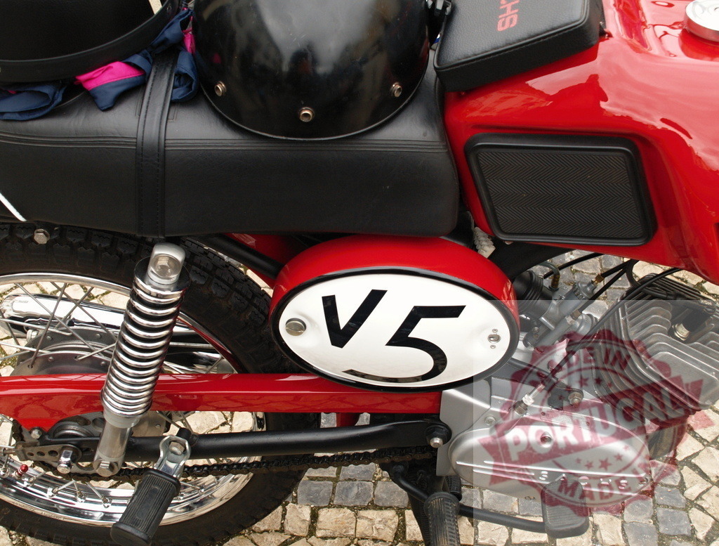 Red sachs motorcycle parked with helmets resting on seat | Close-up of vintage red sachs motorcycle parked on cobblestone street with helmets on seat - Realisiert mit Pictrs.com