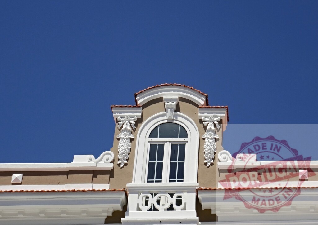 Ornate architectural building facade with blue sky. Aveiro - Portugal | Ornate window and decorative detail on a traditional building facade under clear blue sky - Realized with Pictrs.com