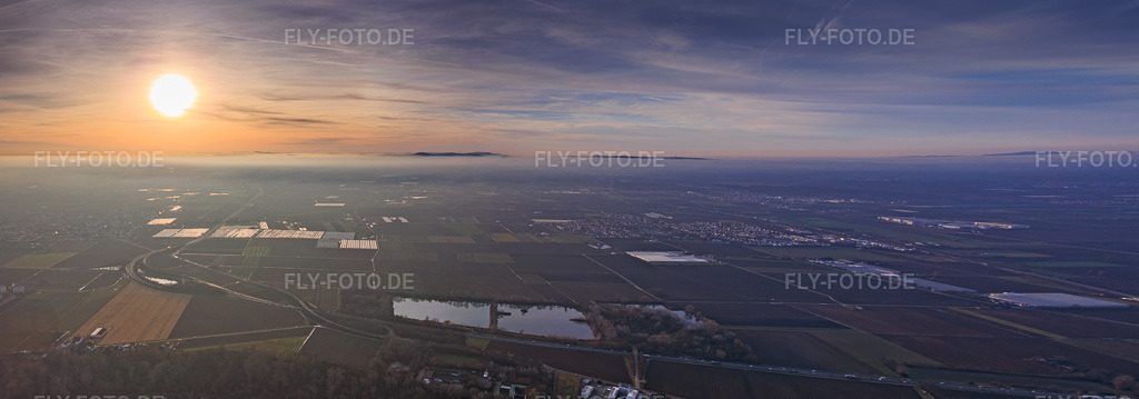 Luftbild: Sonnenuntergang im Nebel jenseits der B9 über dem Scheller Weiher, Foliengewöchshäuser der P.+H. Fehmel Gemüsebau - FeSa Obst-& Gemüsehandels GmbH in Mutterstadt im Bundesland Rheinland-Pfalz in Deutschland. Foto: IMG_152069-Pano.jpg vom 12.12.2025 durch Werner Riehm/FLY-FOTO.deAuflösung des Originals: 11779 x 4125 px