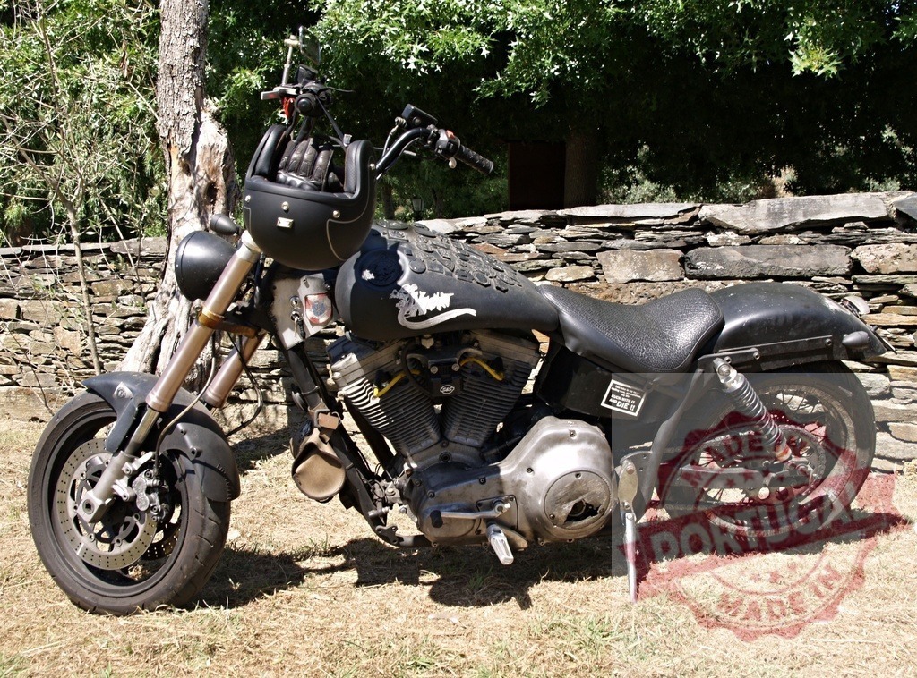 Customized motorcycle parked near stone wall displays helmet and gloves | Powerful customized motorcycle parked near a stone wall, ready for the next adventure - Realized with Pictrs.com