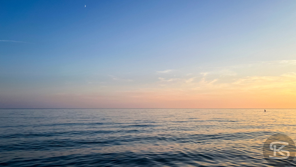 Sonnenuntergang am Mittelmeerstrand in der Camargue – Südfrankreich | Stimmungsvolles Panorama der Küste bei Saintes-Maries-de-la-Mer in der Camargue mit Sandstrand, ruhigen Wellen im goldenen Abendlicht und Silhouetten von Menschen im Wasser. - Realisiert mit Pictrs.com