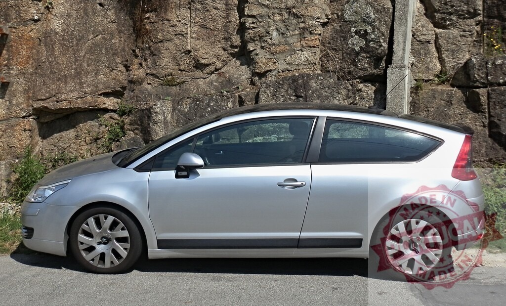 Silver Citroën C4 coupe parked by rock wall | Modern silver Citroën C4 coupe parked on a road next to a rough rock wall - Realized with Pictrs.com