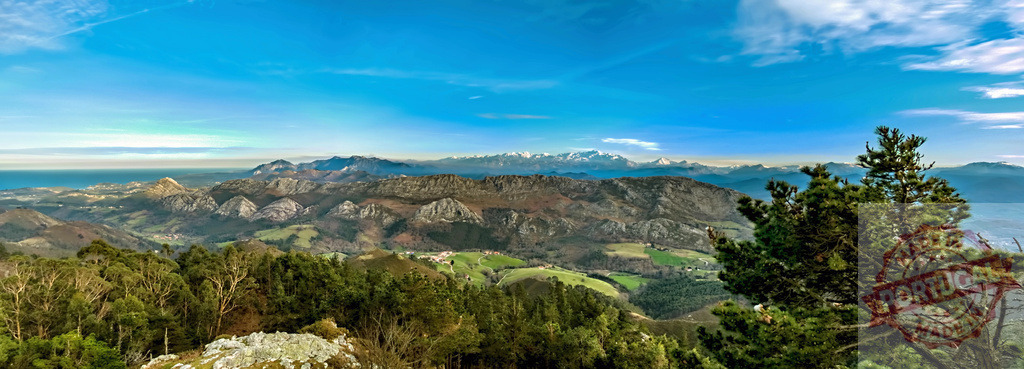 Breathtaking panoramic landscape showing mountains meeting the Cantabrian Sea in Asturias, Spain | Stunning view of the Picos de Europa mountain range and the Cantabrian Sea under a vibrant blue sky in Asturias, Spain - Realisiert mit Pictrs.com