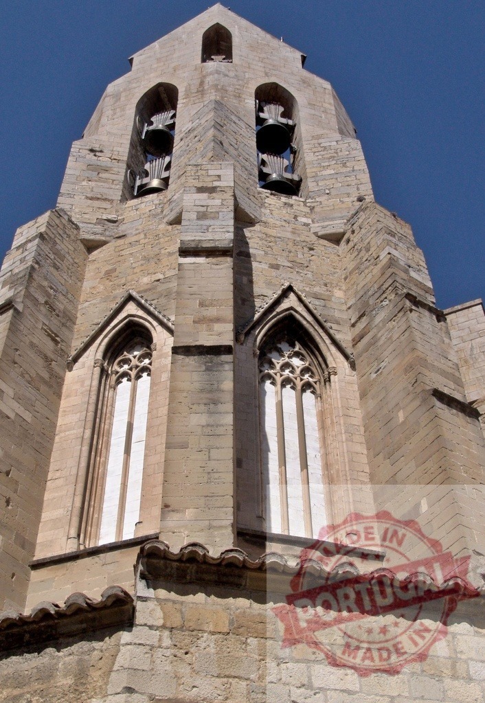 Ancient stone church bell tower against blue sky | Stone bell tower of a historic church rising against a clear blue sky - Realized with Pictrs.com