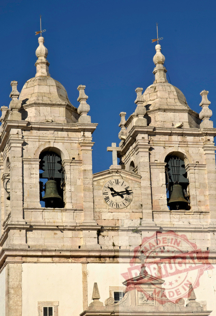 Baroque church bell towers with clock and cross | Ornate stone facade of a historic church against a clear blue sky in Portugal - Realized with Pictrs.com