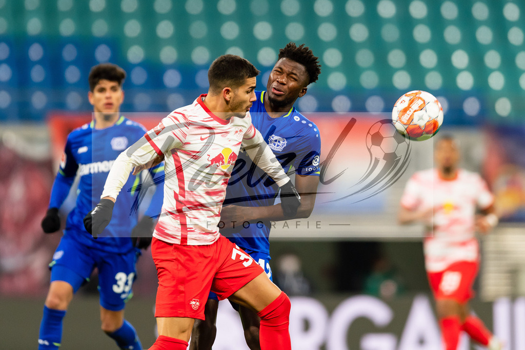 RBLLEV20211128_080 | Fussball, Herren: Andre Silva (RB Leipzig) und Edmond Tapsoba (Bayer 04 Leverkusen) im Zweikampf bei dem Spiel der 1. Bundesliga zwischen RB Leipzig und Bayer 04 Leverkusen in der Red Bull Arena am 28.11.2021 in Leipzig, Deutschland.DFB / DFL REGULATIONS PROHIBIT ANY USE OF PHOTOGRAPHS AS IMAGE SEQUENCES AND/OR QUASI-VIDEO. - Realisiert mit Pictrs.com
