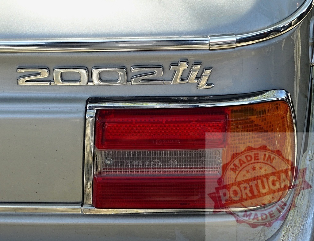 Chrome emblem and taillight on vintage BMW 2002 tii | Rear view showing the classic taillight and chrome emblem of a vintage BMW 2002 tii car - Realisiert mit Pictrs.com