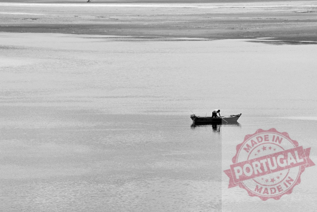 Lone fisherman working on boat in vast water. Galicia - Spain | Fisherman works on his small boat, navigating calm, open water in monochrome - Realisiert mit Pictrs.com