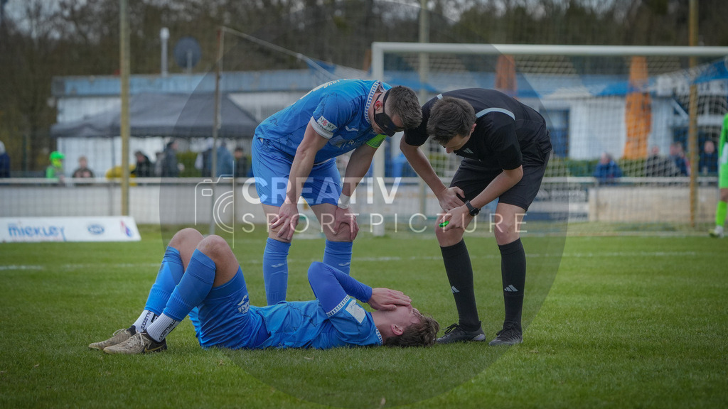 Fußball, Herren, Saison 2025/2026, Landespokal Brandenburg, Halbfinale, RSV Eintracht 1949 vs. VfB 1921 Krieschow, Samstag 28.03.2026, Sportplatz-Heinrich-Zille-Straße | Fußball, Herren, Saison 2025/2026, Landespokal Brandenburg, Halbfinale, RSV Eintracht 1949 vs. VfB 1921 Krieschow, Samstag 28.03.2026, Sportplatz-Heinrich-Zille-Straße, Im Bild: Till Plumpe (RSV) liegt auf dem Boden. Matthias Steinborn (l. RSV) und Schedsrichter Tim Gerstenberg (r.) schauen nach. - Realisiert mit Pictrs.com