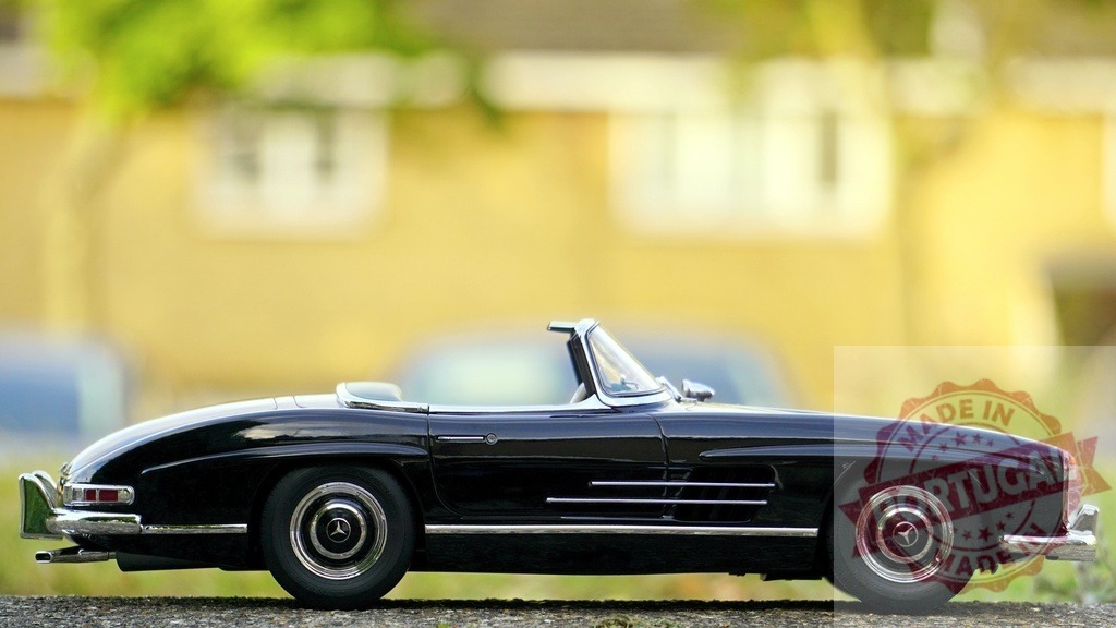 Mercedes-Benz 300 SL toy car model on street | Classic black Mercedes-Benz 300 SL convertible miniature car - Realized with Pictrs.com