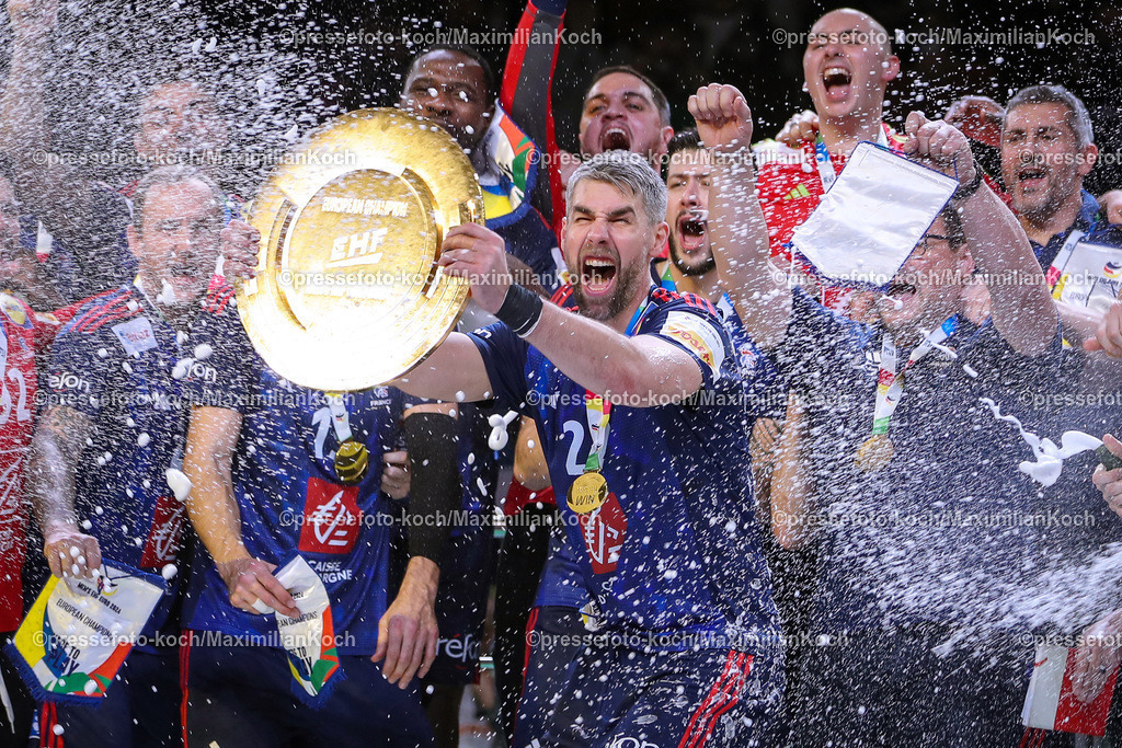 EHFEURO28012402100 | 28.01.2024, EHF EURO 2024, Männer Europameisterschaft Handball, Lanxess Arena in Köln, Finale, Frankreich - Dänemark: Frankreich ist Europameister. Die französische Mannschaft feiert den Sieg gegen Dänemark. Siegerehrung auf dem Siegerpodest. Luka Karabatic (Frankreich) hällt die Siegerschale nach Oben. Es regnet Konfetti und eine Feuershow erhellt im Hintergrund das Podest.