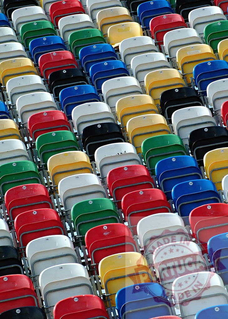 Colorful stadium seats awaiting spectators | Rows of empty colorful stadium seats creating a vibrant pattern, waiting for the crowd to arrive - Realized with Pictrs.com