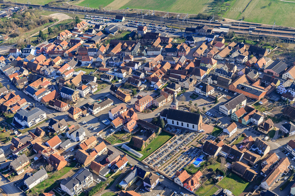 Aerial view: Cimetière communal den Mommenheim and Eglise Catholique in Mommenheim in the state Bas-Rhin, France. – Photo: IMG_097622.jpg taken on 03/16/2017 by Werner Riehm/FLY-FOTO.com – Resolution of the original: 4897 x 3265 px