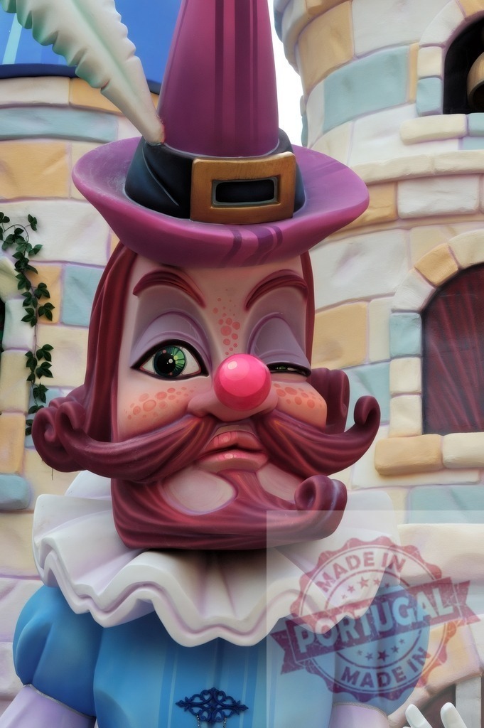Fantasy character winking at Valencia Las Fallas festival. Fallas Fiestas Communidad Valenciana | Whimsical character sculpture with purple hat, red beard, and large pearl green eye - Realized with Pictrs.com