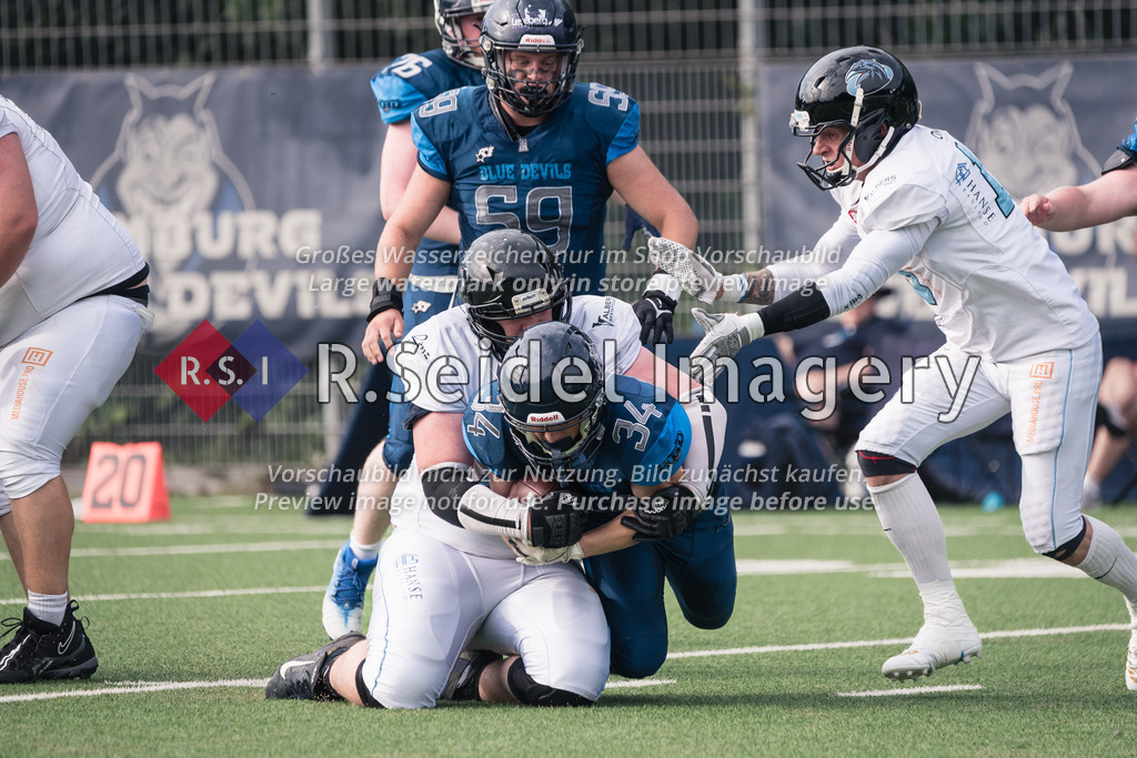 RS-1-131228 | Ryan McVeigh (#77, Ravens) tackelt Ben Thiessen (#34, Blue Devils). Hinten: Janik Strauß (#59, Blue Devils), rechts: Helge Lohmann (#15, Ravens).