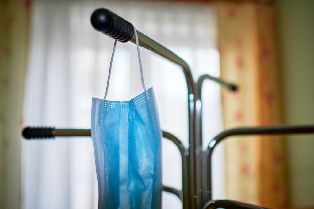 Blaue Mund- und Nasenmaske | Wien, Austria - April 17, 2020: Massnahmen zur Einschränkung von COVID-19; blaue Mund- und Nasenmaske auf dem Kleiderständer. - Realisiert mit Pictrs.com