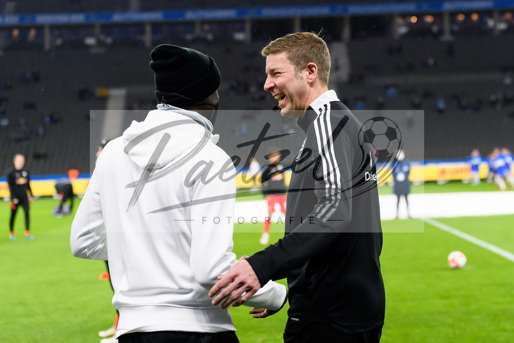 BSCRBL20220220_260 | Fussball, Herren: Schiedsrichterassistent Guido Kleve und Teammanager Babacar N'Diaye (RB Leipzig) begruessen sich bei dem Spiel der 1. Bundesliga zwischen Hertha BSC und RB Leipzig im Olypiastadion am 20.02.2022 in Berlin, Deutschland.DFB / DFL REGULATIONS PROHIBIT ANY USE OF PHOTOGRAPHS AS IMAGE SEQUENCES AND/OR QUASI-VIDEO. - Realisiert mit Pictrs.com