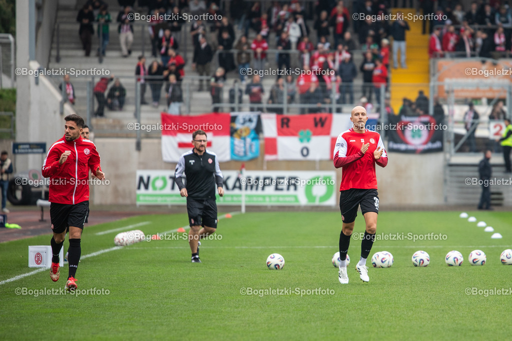 Aufwärmen RWE | 11.10.2025, Fußball, Niederrheinpokal, Rot-Weiß Oberhausen - Rot-Weiss Essen: Rot-Weiss Essen kommt zum Aufwärmen aus der Kabine. Auf dem Bild: Tobias Kraulich (Rot-Weiss Essen #33), Ahmet Arslan (Rot-Weiss Essen #6) und Co-Trainer Paul Freier (Rot-Weiss Essen) - Realisiert mit Pictrs.com