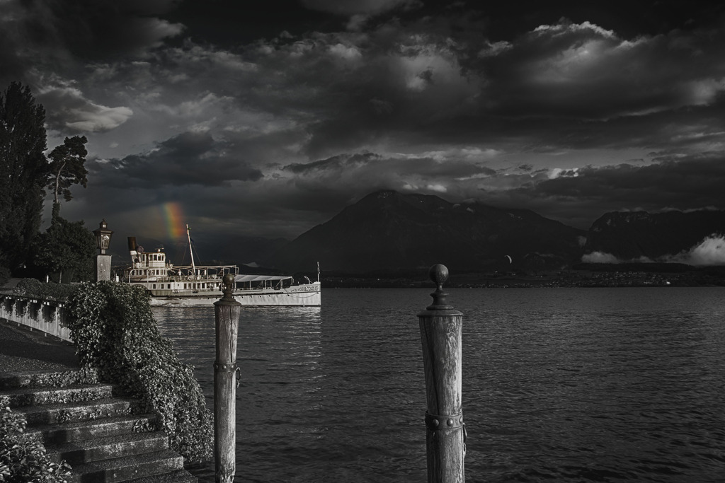 Rainbow Fragment | Keine Silber- aber bunte Streifen am Horizont. DS Blümlisalp bei der Ländte Hilterfingen mit einem kleinen Abschnitt eines Regenbogens in Selektivfarben.
http://art.hess.photography/4-15-blueemlere.html
-----------------------------------------------
No silver but coloured lining on the horizon. DS Blümlisalp near the Hilterfingen jetty with a small section of a rainbow in selective colors.
-----------------------------------------------
Dieser Druck ist in einer limitierten Auflage von 10 Exemplaren erhältlich. 
This print is available in a limited edition of 10 copies. 
http://art.hess.photography/4-15-blueemlere.html - Realisiert mit Pictrs.com