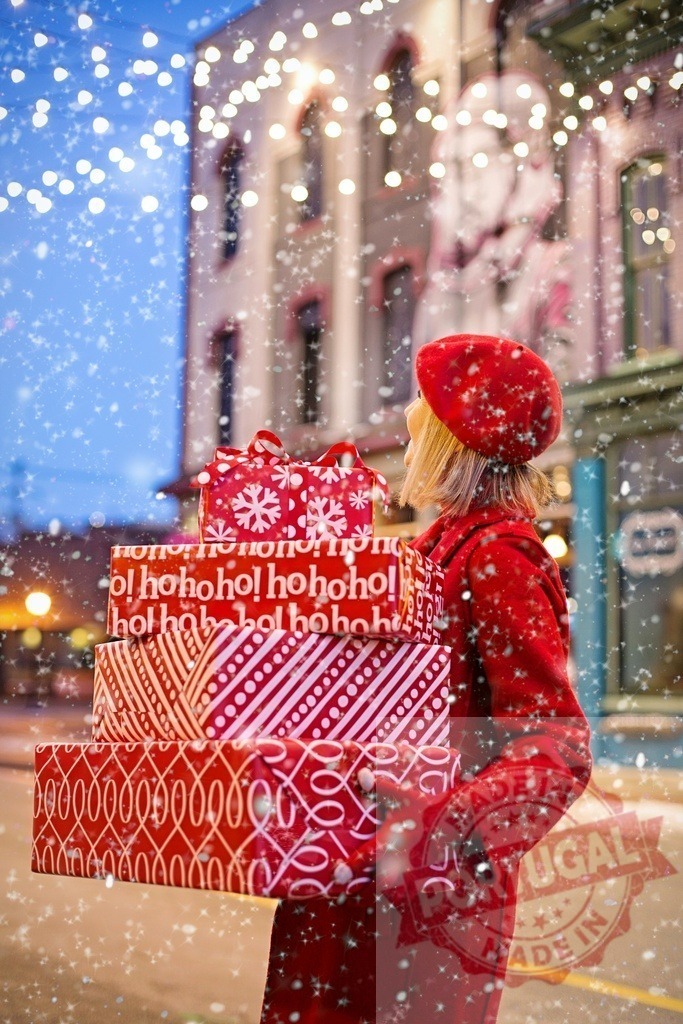 Woman carrying Christmas gifts during snowfall | Woman carrying many Christmas gifts is walking in a decorated city during snowfall - Realisiert mit Pictrs.com