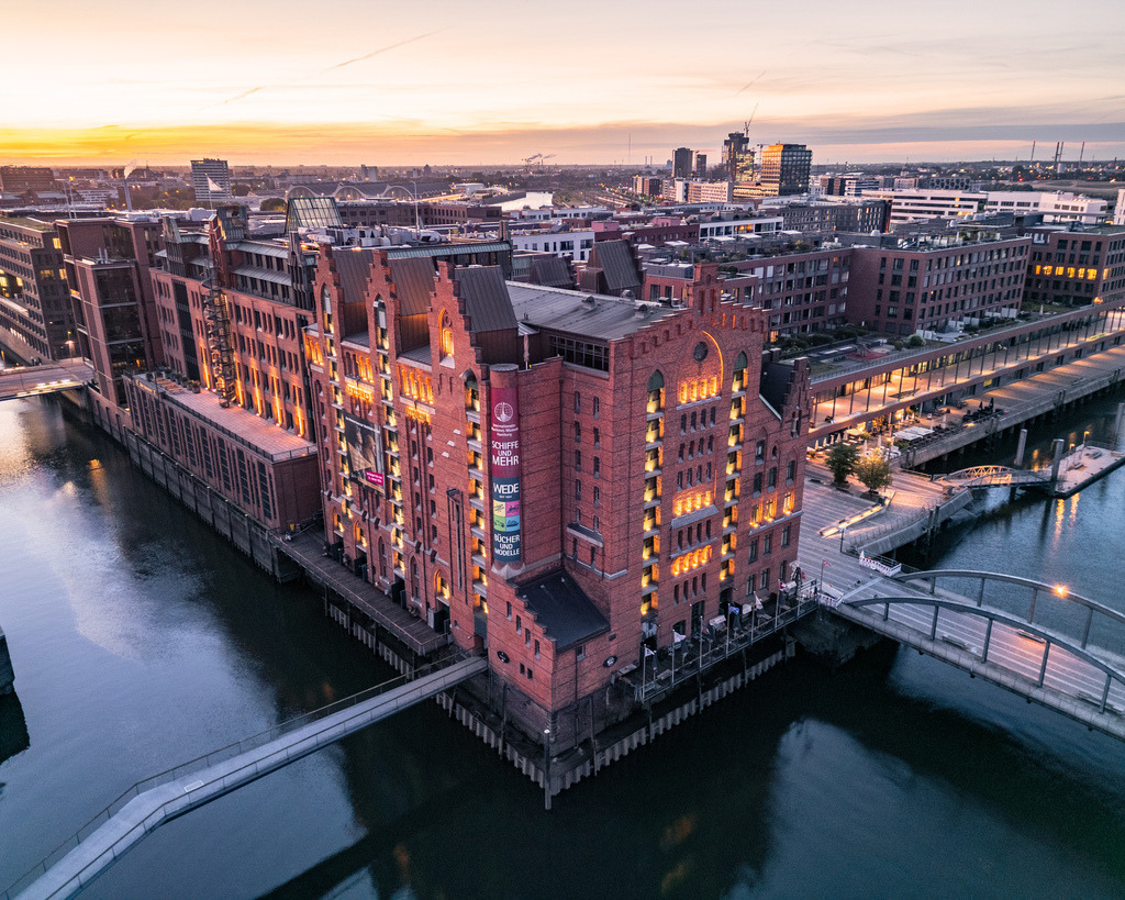 Speicherstadt aus der Vogelperspektive | Außergewöhnlicher Blick aus der Luft auf die historischen Backsteingebäude, Brücken und Fleete der Hamburger Speicherstadt im Abendlicht. - Realisiert mit Pictrs.com