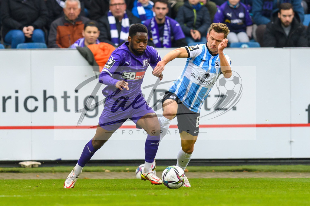 OSNTSV20211106_098 | Fussball, Herren: Ba-Muaka Simakala (VfL Osnabrueck) und Erik Tallig (TSV 1860 Muenchen) im Zweikampf bei dem Spiel der 3. Liga zwischen VfL Osnabrueck und TSV 1860 Muenchen im Stadion an der Bremer Bruecke am 06.11.2021 in Osnanbrueck, Deutschland.DFB / DFL REGULATIONS PROHIBIT ANY USE OF PHOTOGRAPHS AS IMAGE SEQUENCES AND/OR QUASI-VIDEO. - Realisiert mit Pictrs.com