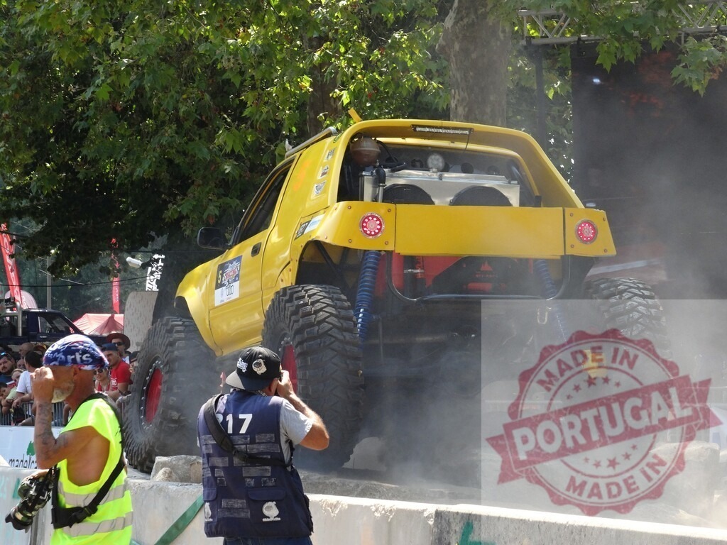 Yellow off-road vehicle making dust during an outdoor competition | Powerful yellow off-road vehicle making dust during an outdoor competition with photographers taking pictures - Realisiert mit Pictrs.com