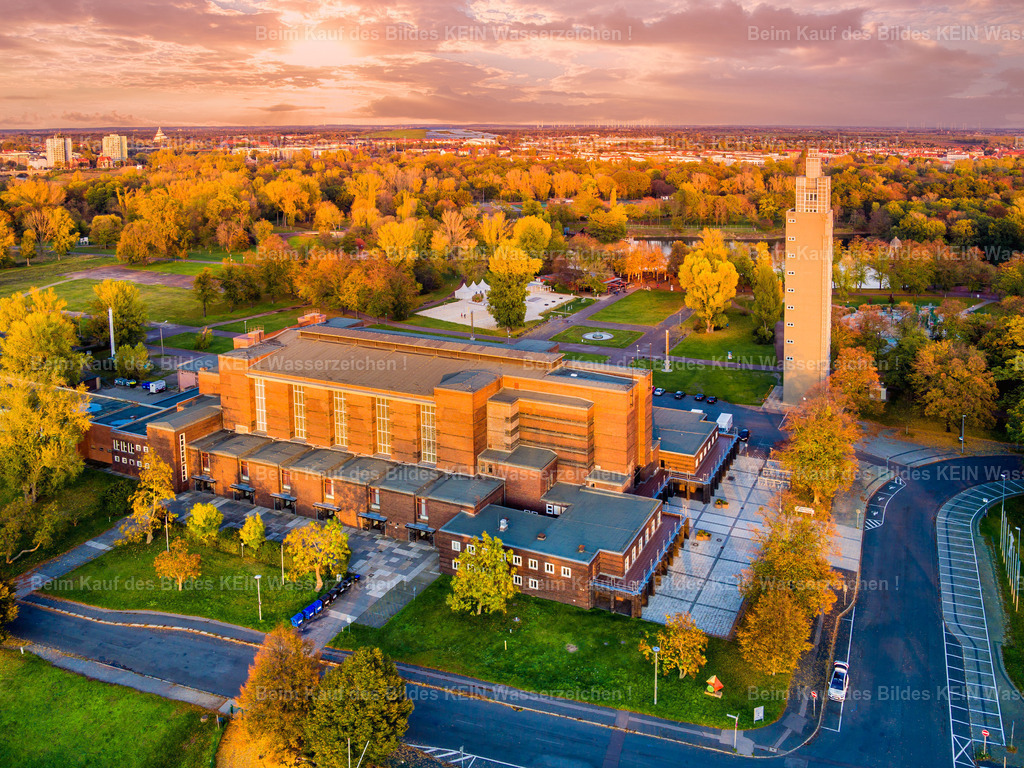 Stadthalle und Aussichtsturm Magdeburg im roten Abendlicht im Stadtpark Rothehorn-0040 | Die Stadthalle Magdeburg liegt im warmen roten Licht des ausklingenden Tages. Die markante Architektur des historischen Gebäudes hebt sich vor dem farbigen Abendhimmel ab und verleiht dem bekannten Bauwerk eine besonders intensive und stimmungsvolle Wirkung. - Realisiert mit Pictrs.com