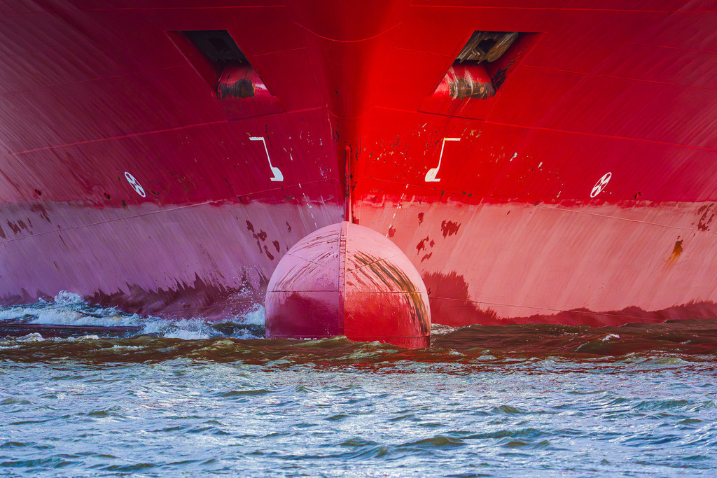 Bugansicht CONTAINERSHIPS VIII | Nahaufnahme des Bugs des Containerschiffs CONTAINERSHIPS VIII. Das Bild zeigt den markanten Wulstbug und die leuchtend rote Rumpffärbung des Frachters kurz über der Wasserlinie. - Realisiert mit Pictrs.com