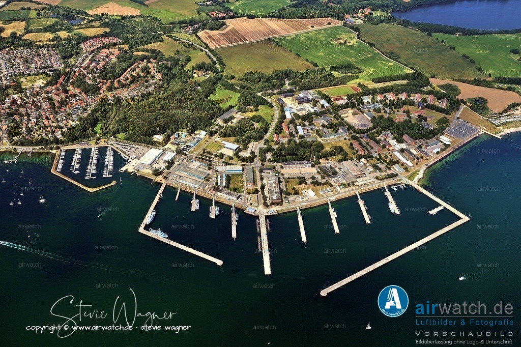 Luftbild Eckernförde - Der Marinestützpunkt ist ein bedeutender Wirtschaftsfaktor für die Stadt Eckernförde | Zusätzlich plant die Bundeswehr, bis 2025 ein neues Schießausbildungszentrum für das Kommando Spezialkräfte der Marine auf dem Gelände der Hindernisbahn zu errichten, was ab 2025 die Durchführung von Spitzensport am Standort nicht mehr ermöglichen wird. Die Bundeswehr plant zudem weitere Investitionen in Höhe von insgesamt 500 Millionen Euro, wobei der Schwerpunkt auf den Pieranlagen und der Verbesserung der Infrastruktur für die neuen U-Boote liegt, die gemeinsam mit Norwegen beschafft werden. Die Personalstärke soll mittelfristig auf 4.000 Dienstposten anwachsen. Der Marinestützpunkt ist ein bedeutender Wirtschaftsfaktor für die Stadt Eckernförde, die mit rund 2.000 Soldatinnen und Soldaten beheimatet sind.