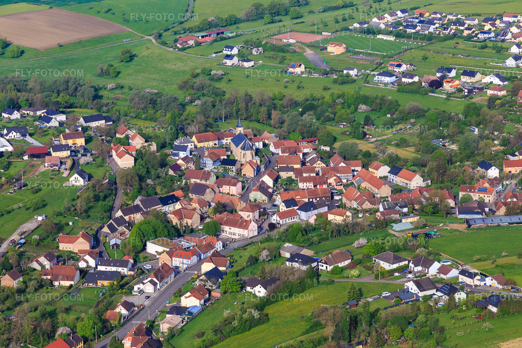 Aerial view: Village center from the east in Gros-Réderching in the state Moselle, France. – Photo: IMG_140679.jpg taken on 05/01/2024 by Werner Riehm/FLY-FOTO.com – Resolution of the original: 5472 x 3648 px