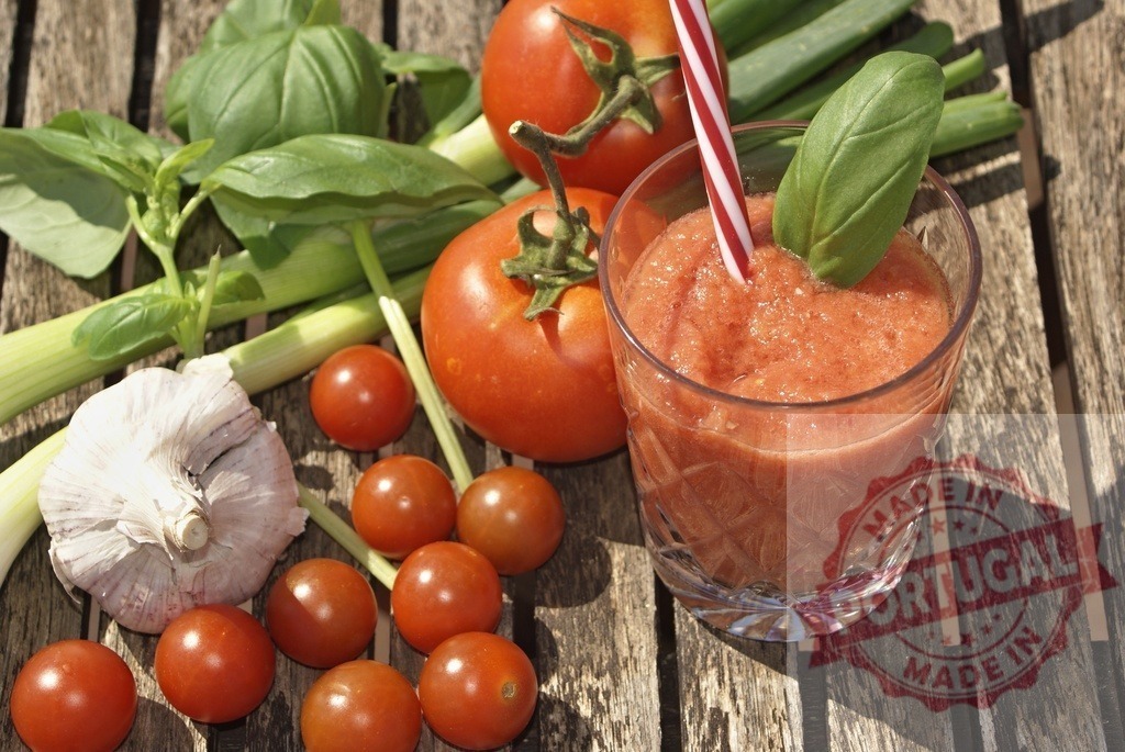 Refreshing gazpacho drink with fresh tomatoes and basil | Fresh gazpacho in a glass with a straw, surrounded by organic ingredients on a wooden table - Realized with Pictrs.com
