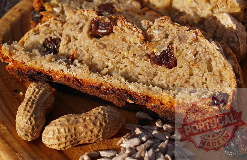 Homemade raisin and sunflower seed bread slice | Freshly baked bread slice with raisins and sunflower seeds on a wooden board - Realisiert mit Pictrs.com