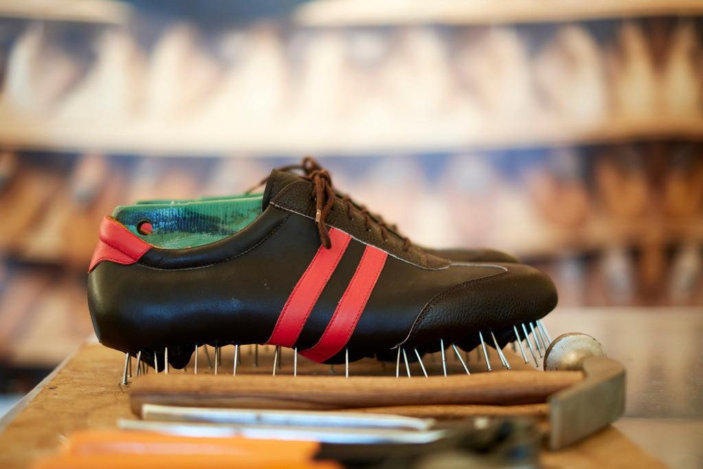 Handgemachte Schuhe in der Werkstatt | Neumarkt an der Raab, Austria - September 18, 2021: Bednar und Strunz, handgemachte Schuhe in der Werkstatt, im Hintergrund ein Bild mit Holzleisten. - Realisiert mit Pictrs.com