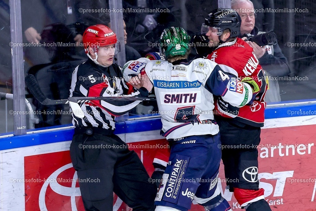 KEC15042601166 | 15.04.2026, Eishockey, DEL Halbfinale Play-Offs, Kölner Haie - Eisbären Berlin, Spiel 4, Lanxess-Arena Köln: Adam Smith (Eisbären Berlin #04) im Zweikampf gegen Valtteri Kemiläinen (Kölner Haie #13) an der Bande