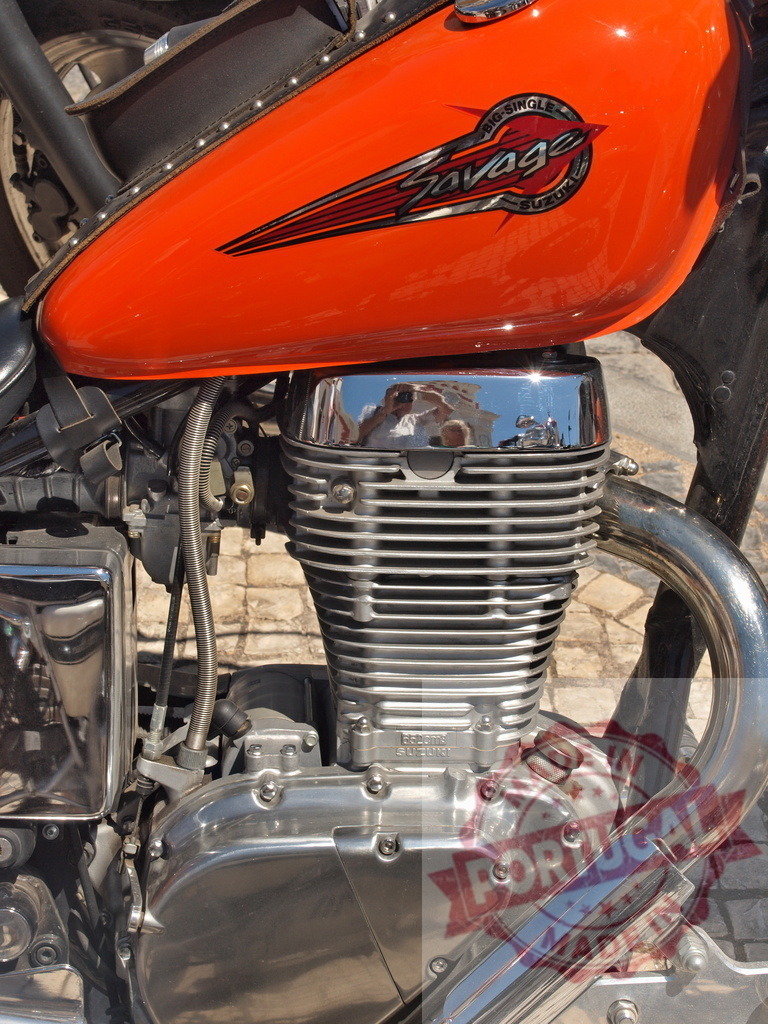 Suzuki Savage motorcycle engine and orange fuel tank | Suzuki Savage motorcycle with a big single engine and orange fuel tank in close-up - Realisiert mit Pictrs.com