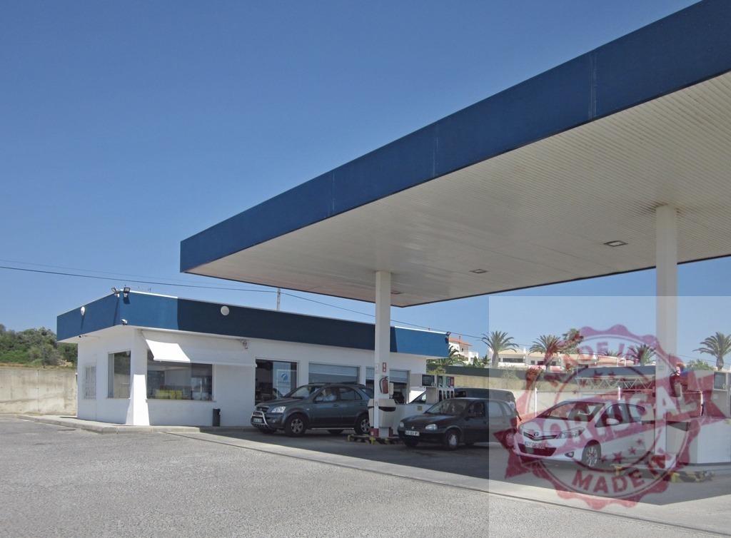 Blue and white gas station pumping fuel for car travel | Gas station canopy covering cars fueling up on a clear sunny day - Realisiert mit Pictrs.com