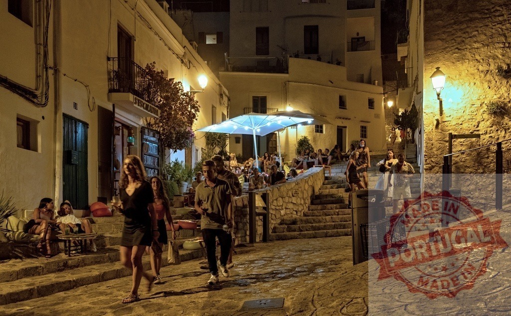 People enjoying nightlife and walking historic street in Dalt Vila, Ibiza | Tourists and locals socialising, walking, and relaxing at night on ancient street stairs - Realized with Pictrs.com