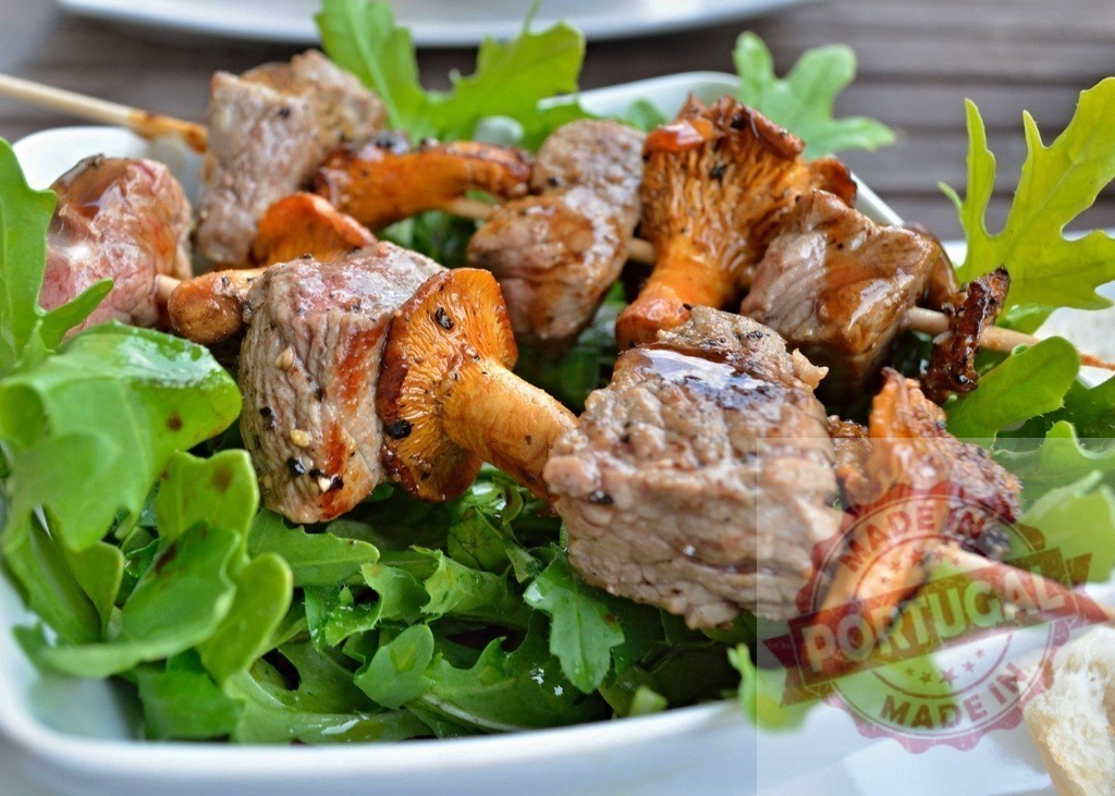 Beef and chanterelle mushroom skewers with arugula salad | Beef and chanterelle mushroom skewers resting on a bed of fresh arugula salad - Realized with Pictrs.com