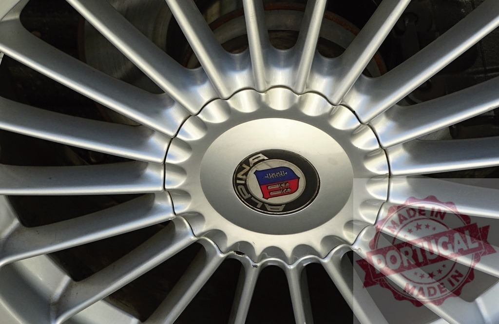 Alpina car wheel showing spokes and emblem | Alpina car wheel with silver spokes and a visible logo - Realisiert mit Pictrs.com