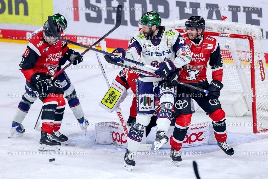 KEC15042601070 | 15.04.2026, Eishockey, DEL Halbfinale Play-Offs, Kölner Haie - Eisbären Berlin, Spiel 4, Lanxess-Arena Köln: Andreas Eder (Eisbären Berlin #43) im Zweikampf gegen  Valtteri Kemiläinen (Kölner Haie #13) vor dem Tor von Goalie Janne Juvonen (Kölner Haie #30) 