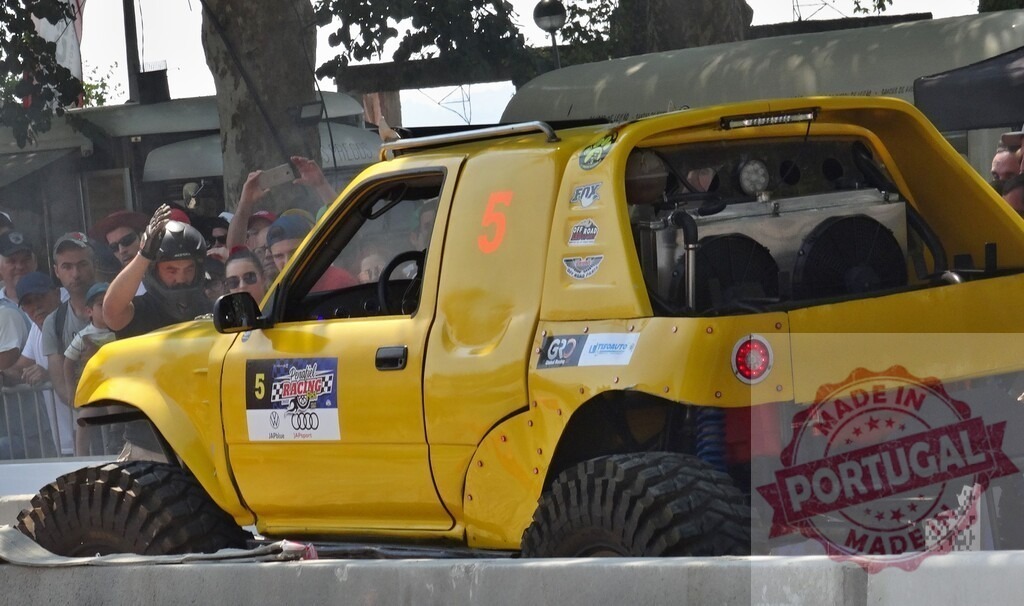 Pilot waving to the public from his tuned toyota truck during an off-road race | Pilot waving to the public from his tuned toyota truck during an off-road race competition - Realized with Pictrs.com