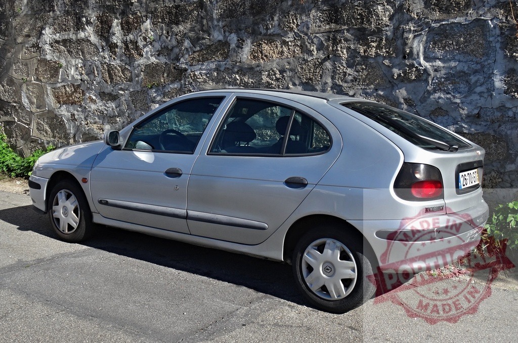 Renault Mégane hatchback car parked on street | Silver Renault Mégane hatchback car parked next to a stone wall on a sunny day - Realisiert mit Pictrs.com
