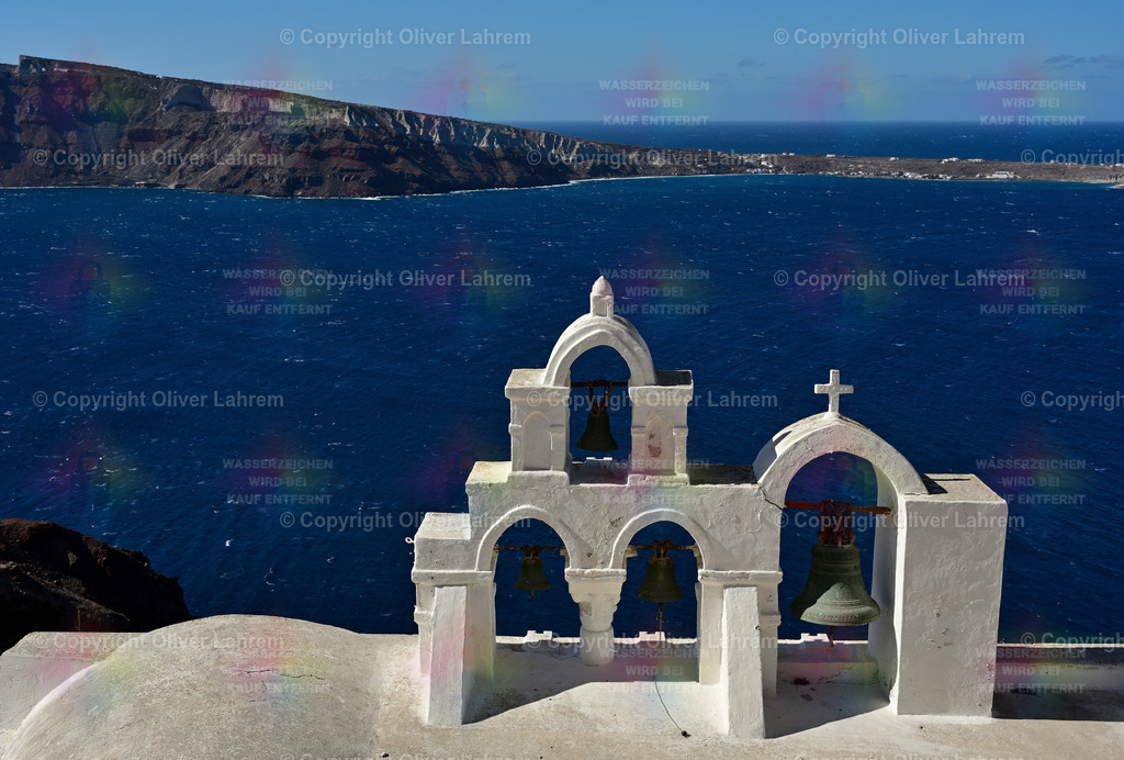 Glocken vor der Insel Thirasia | Einer der typischen Glockentürme auf der Griechischen Insel Santorin bei strahlend blauen Himmel. Im Hintergrund sieht man die Insel Thirasia.