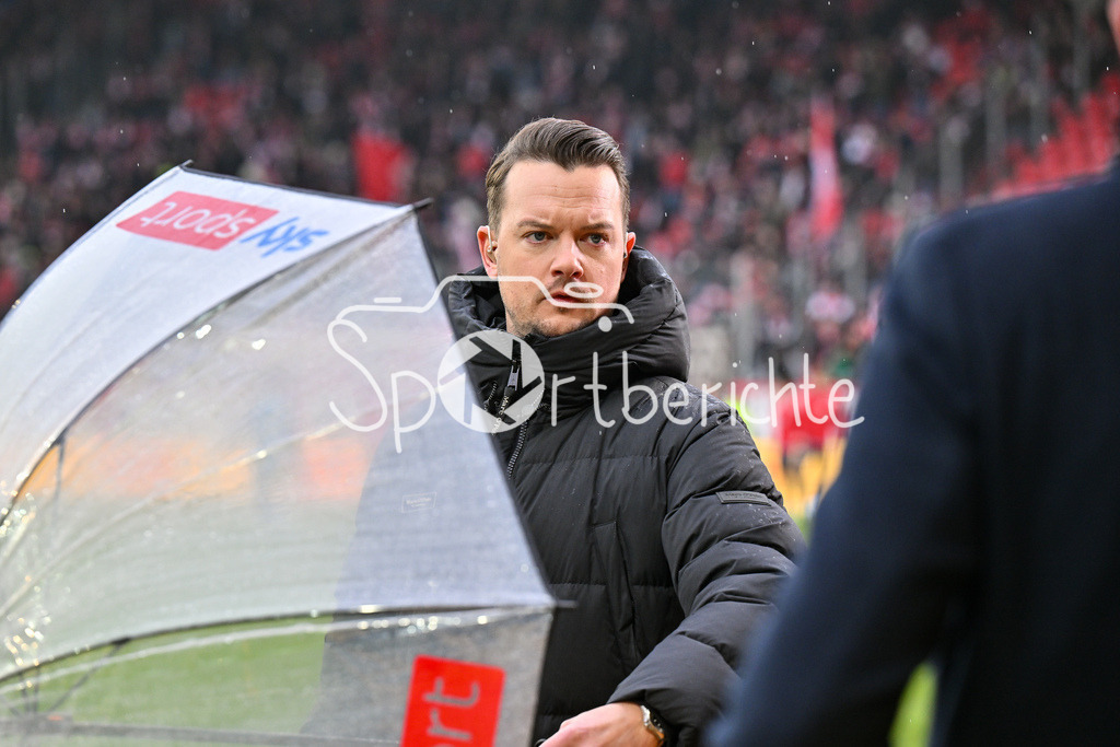 SSV Jahn Regensburg - 1. FC Köln | Im Bild SKY Moderator Florian PLETTENBERG / Freisteller / Einzelfoto / 2. Bundesliga: SSV Jahn Regensburg - 1. FC Koen, Jahnstadion am 08.12.2024 / Regenschirm