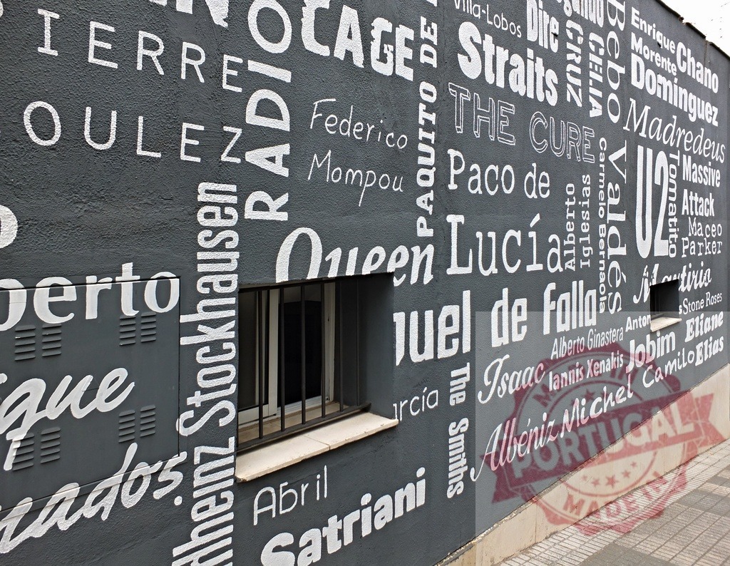 Street art mural with names of musicians and bands | Building facade with typography featuring famous music artist names in black and white - Realized with Pictrs.com
