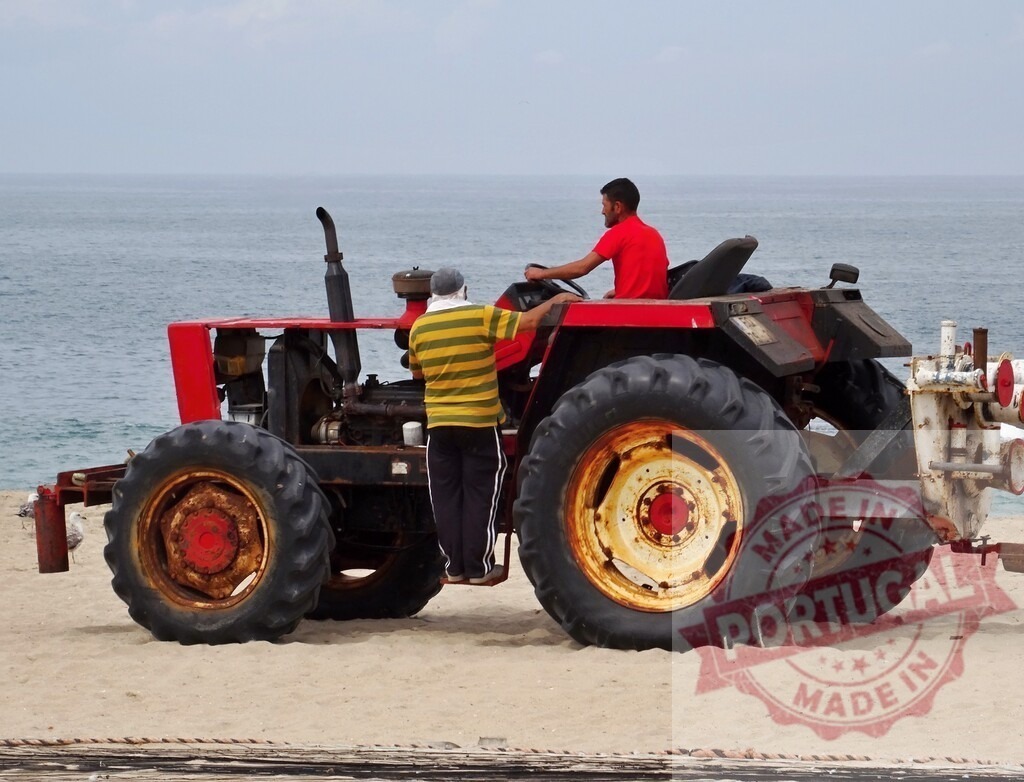 Aveiro Region - Portugal People operating red tractor on sandy beach near ocean | Workers using a heavy duty tractor on the sand with the sea in the background - Realisiert mit Pictrs.com