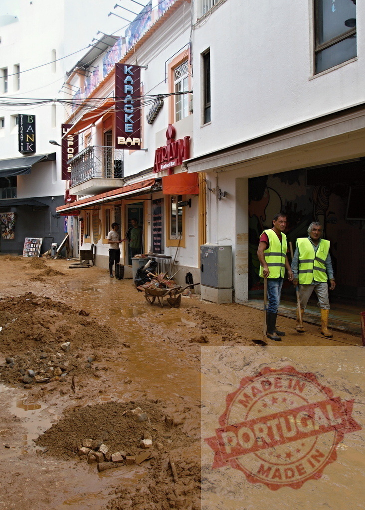 Workers cleaning street from mud after flood disaster | Albufeira Flood - discruction by weather problems Workers clearing mud from a street after a natural disaster - Realized with Pictrs.com
